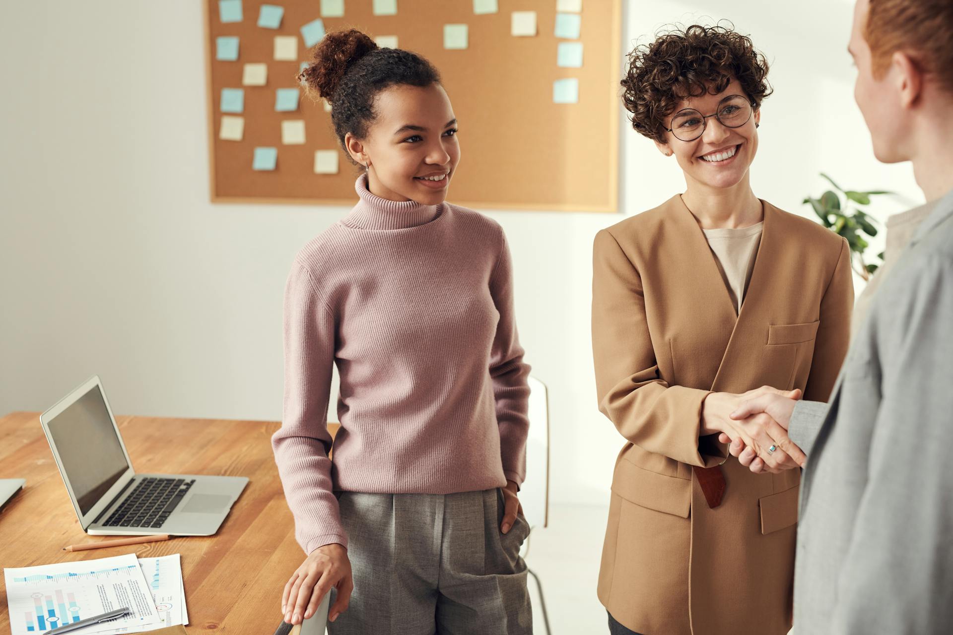 three people having discussion and shaking hands